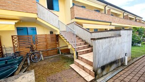 A multi-story building with a staircase leading to the upper floors. - Apartment with premium amenities, Rosolina (Rosolina)