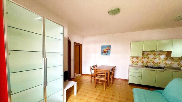 Un espacio habitable pequeño con kitchenette, comedor y sofá.