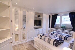 Ein Schlafzimmer mit einem großen Bett, einem eingebauten Kleiderschrank und einem Fernseher.