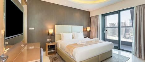 A modern hotel room with a large bed, a TV, and a city view.