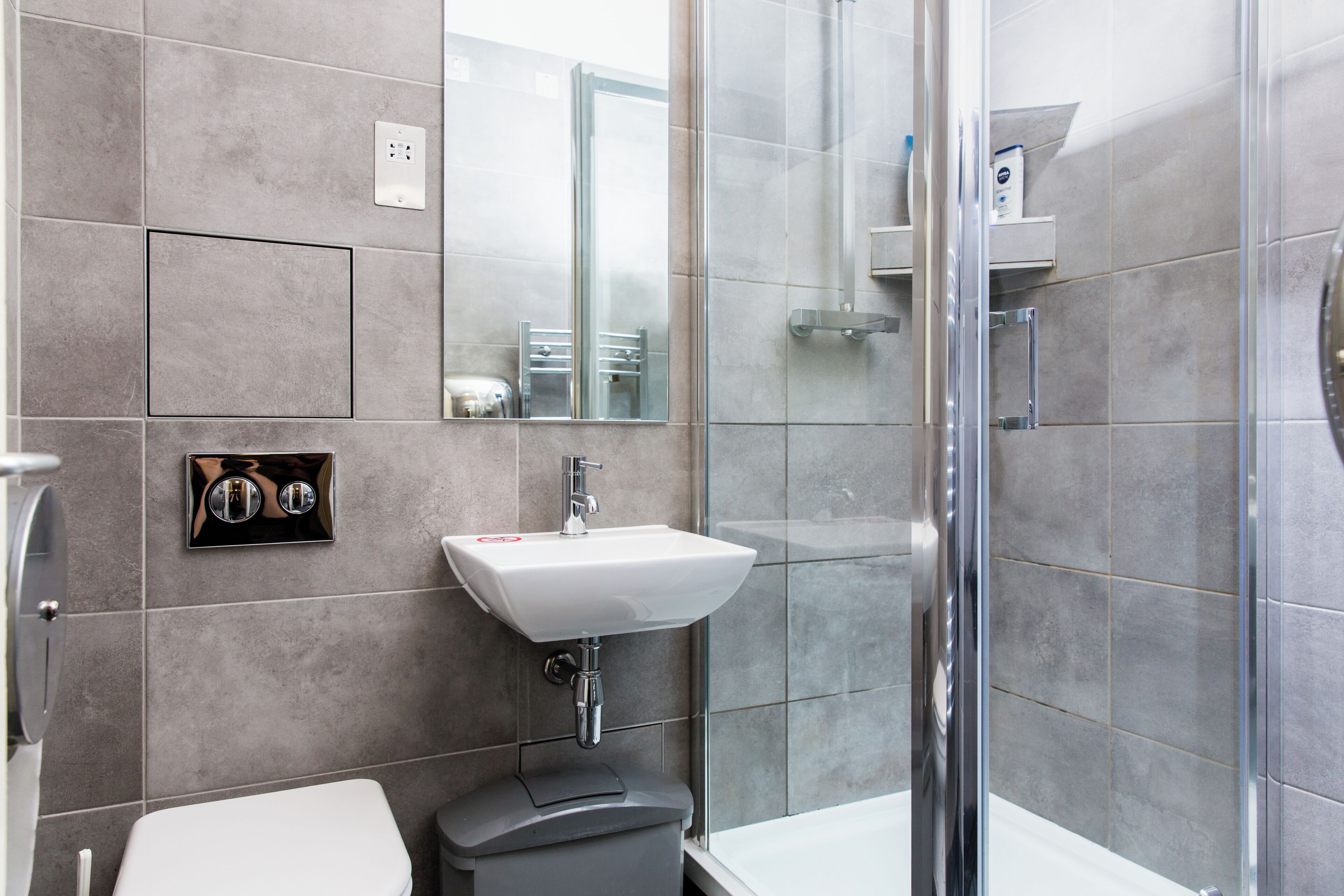 Une salle de bain moderne équipée de toilettes, d’un lavabo et d’une douche.