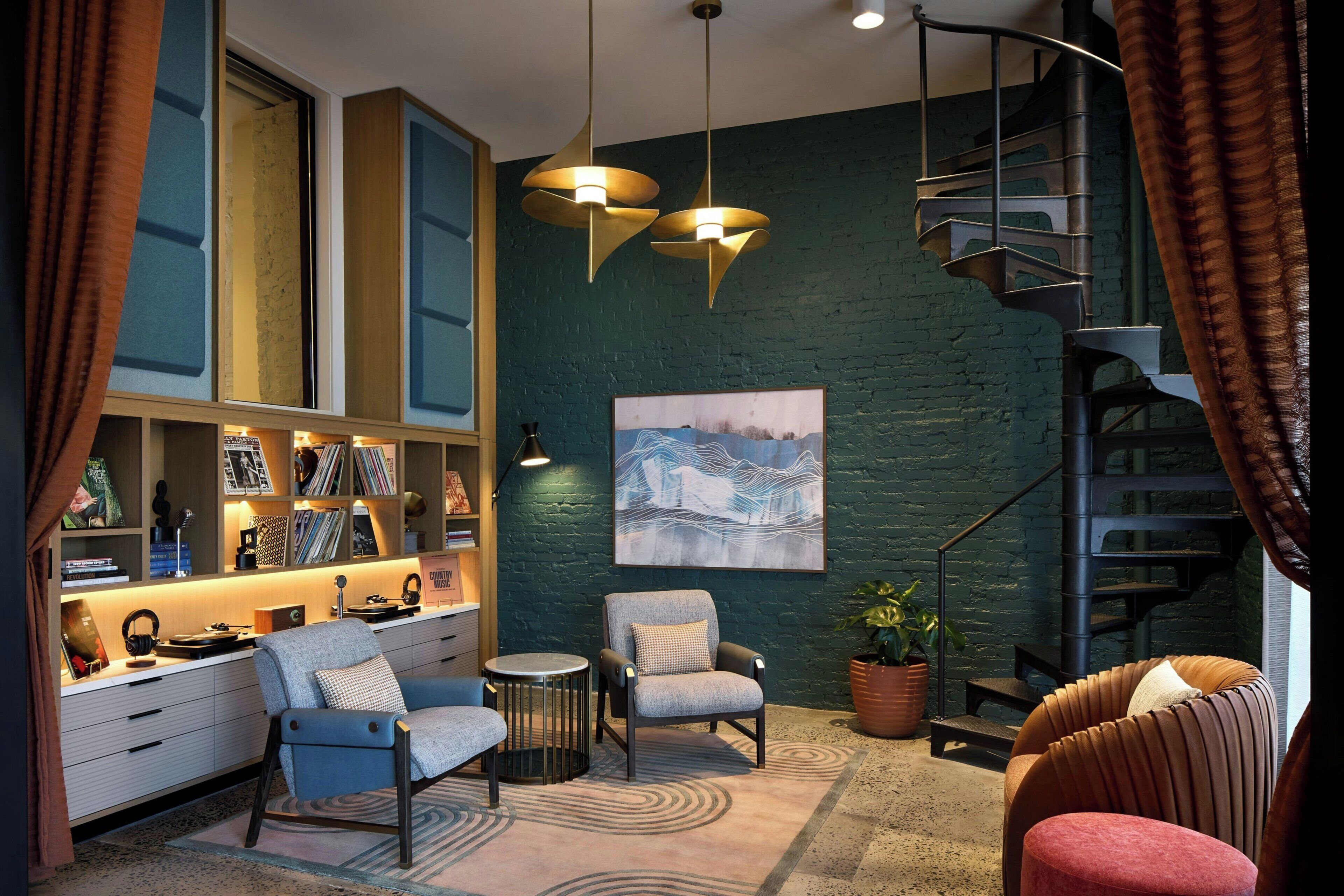 A modern interior with a spiral staircase, a bookshelf, and a seating area.