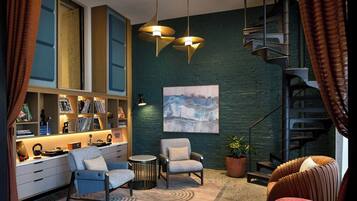 A modern interior with a spiral staircase, a bookshelf, and a seating area.