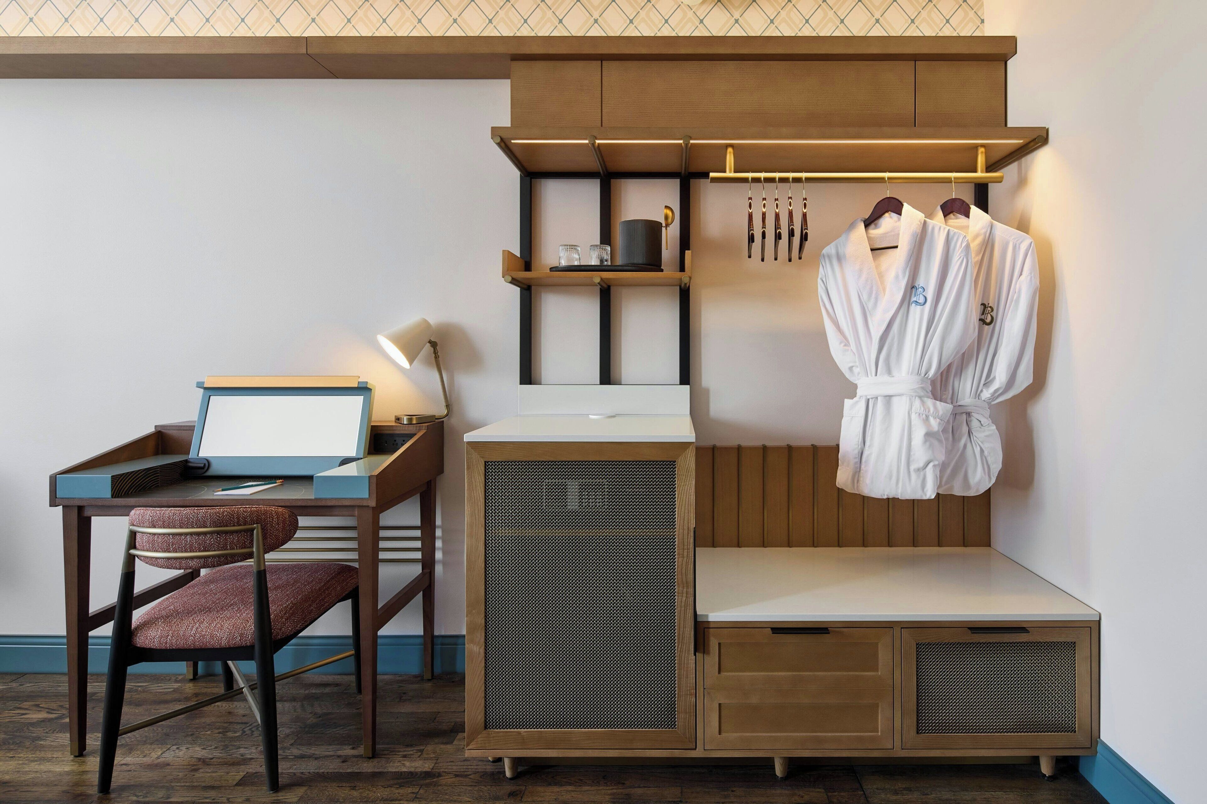A compact room with a desk, chair, and a small seating area.