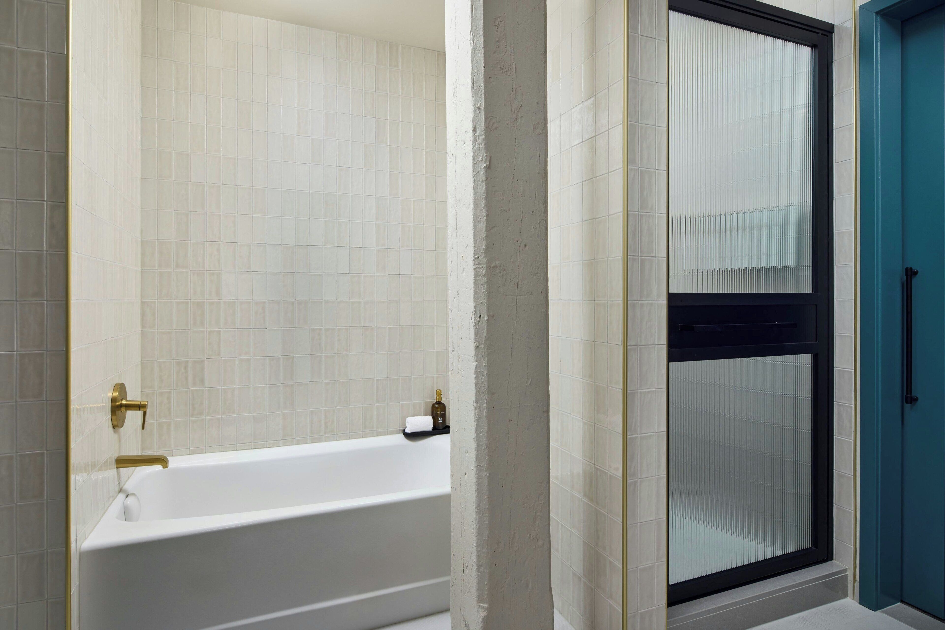 Une salle de bain avec une baignoire blanche, un porte-serviettes et une cabine de douche en verre.