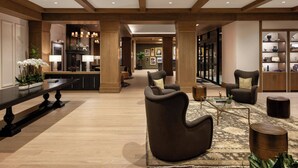 A spacious lobby with a high ceiling, wooden beams, a reception desk, seating area, and a bookshelf. - The Brandywine, Radnor, a Tribute Portfolio Hotel (Wayne)
