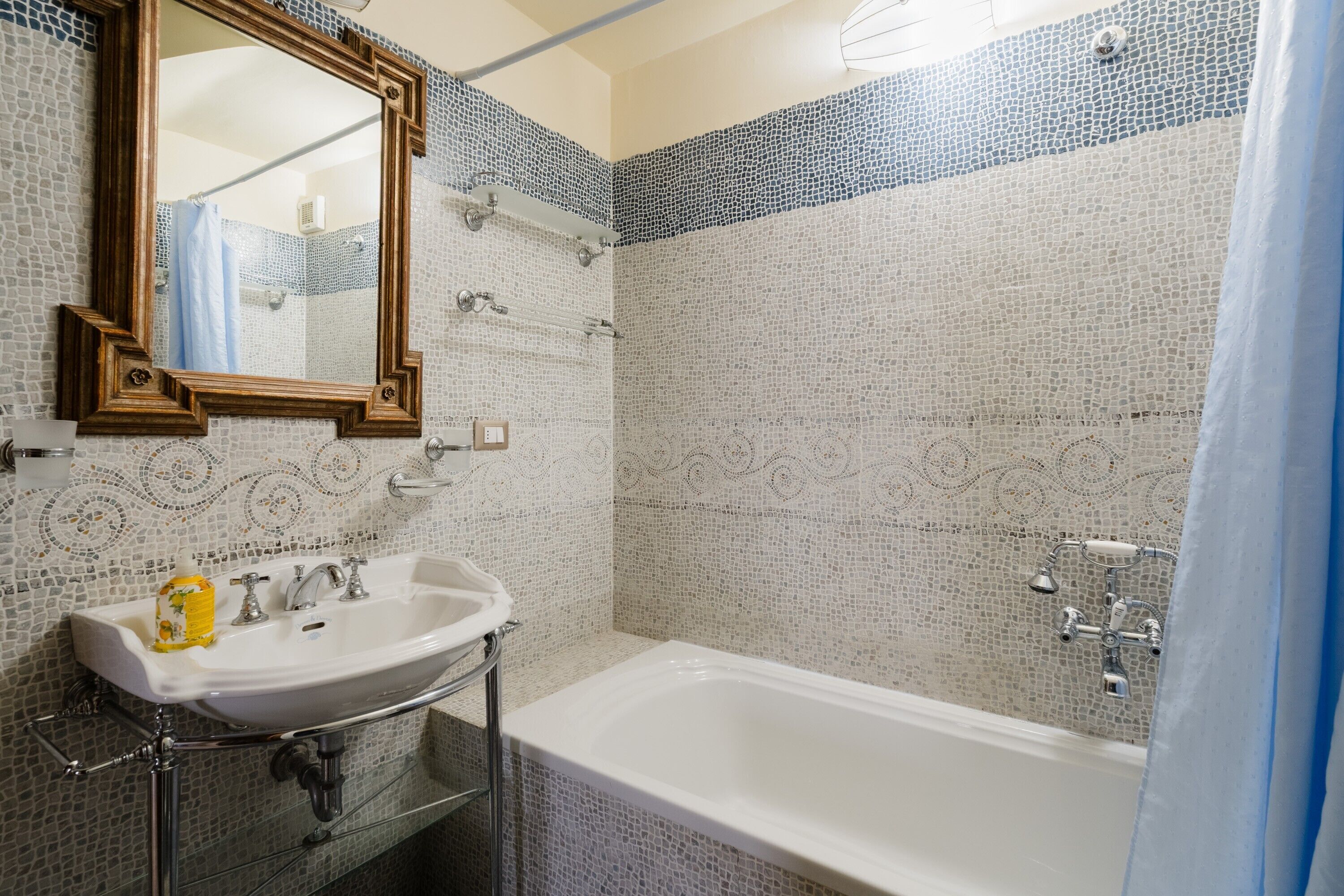 Un bagno con lavabo, specchio e vasca.