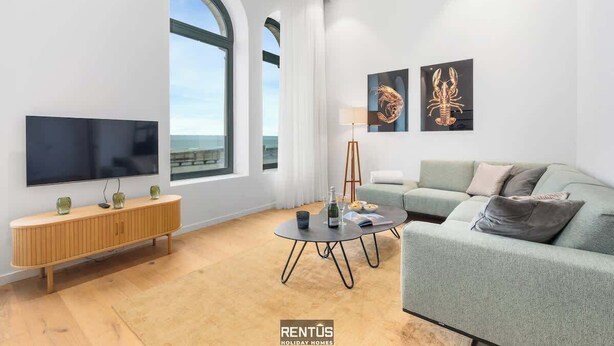 Un soggiorno moderno con una grande TV, un divano, un tavolino da caffè e opere d'arte alle pareti.