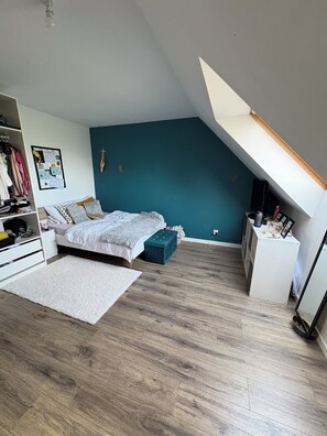 Une chambre à coucher comprenant un lit, une commode, un bureau et une armoire.