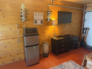 A compact kitchen with a refrigerator, microwave, and a small cabinet. - Beautiful 1-bedroom house with AC in charming Galveston (Galveston)