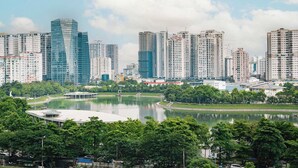Un paisaje urbano con rascacielos, un lago y zonas verdes circundantes.