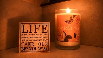 Una candela con decorazioni floreali e un cartello con una citazione sulla vita.