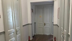 Un pasillo con suelo de madera y puertas blancas.