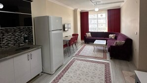 Un espace de vie compact comprenant une cuisine, un coin repas et un coin salon.