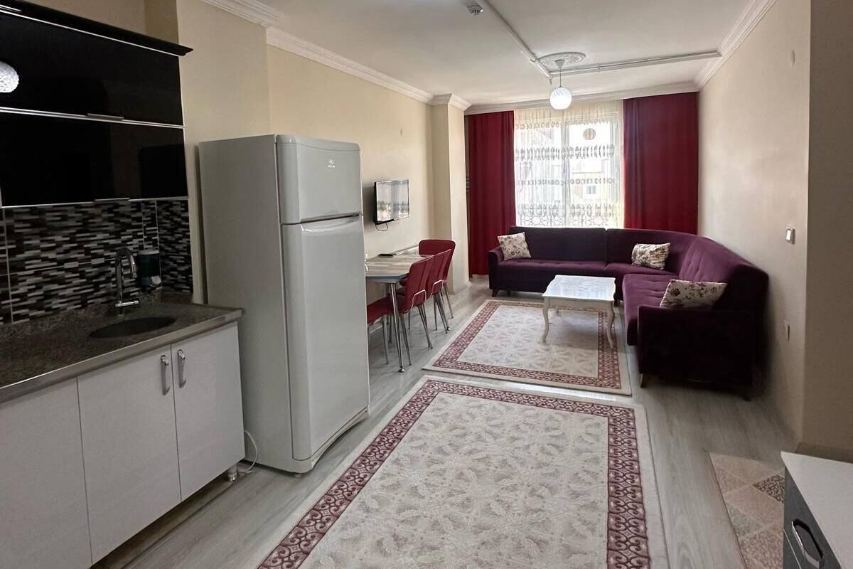 Un espace de vie compact comprenant une cuisine, un coin repas et un coin salon.