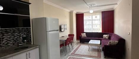 Un espacio habitable compacto con cocina, comedor y zona de estar.