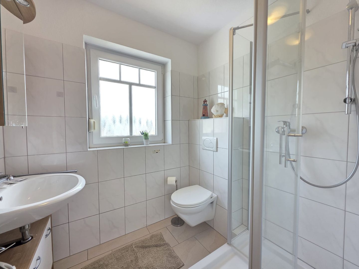 Ein modernes Badezimmer mit Toilette, Waschbecken und Dusche.