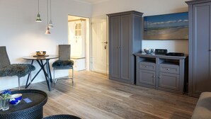 Un espacio habitable compacto con comedor, kitchenette y un amplio armario.