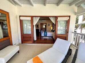Una habitación con cama, sofá y balcón con barandilla.