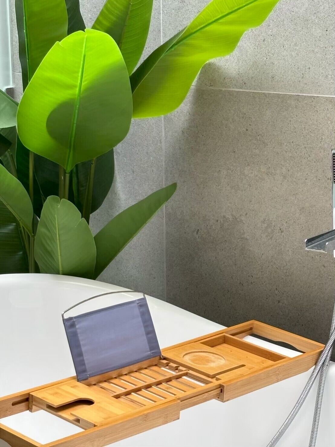 A bathroom with a wooden tray, a blue towel, and a shower head.