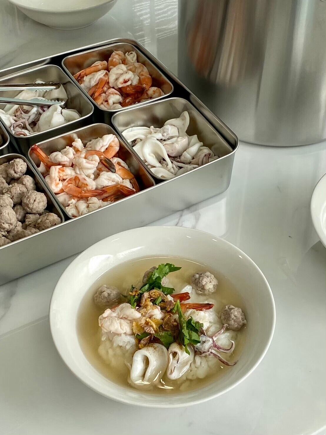 Un plato con mariscos y albóndigas, y una bandeja con diversos mariscos y albóndigas.