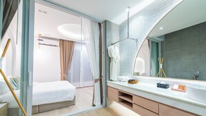 A modern bathroom with a glass shower enclosure, a large mirror, and a white sink. - The Pool Space — ICONIC Pool Villa (Pattaya)