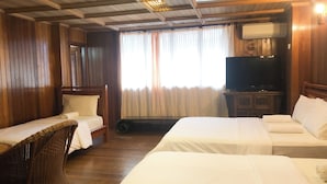 A hotel room with two beds, a television, a wicker chair, and wooden walls. - HOTEL I VILLA INN (Kuala Lumpur)