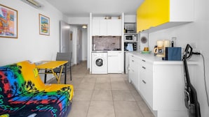 Una cocina compacta equipada con lavadora, microondas y cafetera.