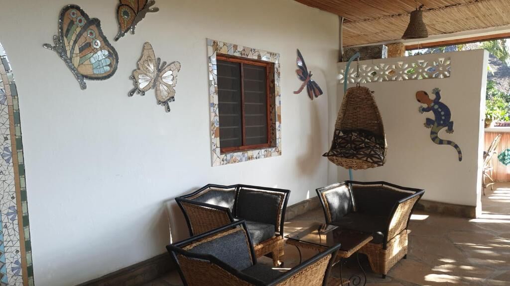 Una habitación con pared de azulejos, una ventana y una maceta colgante.