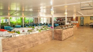 A spacious indoor area with a long counter for food service, surrounded by tables and chairs.