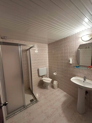 A bathroom with a shower, toilet, sink, and mirror. - Mariva City Beach Otel (Alanya)