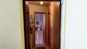 A hallway with wooden doors, a coat rack, and a doormat at the entrance. - Beautiful bright 60 sqm apartment near Magdeburg city center and zoo, barrier-free (Magdeburg)