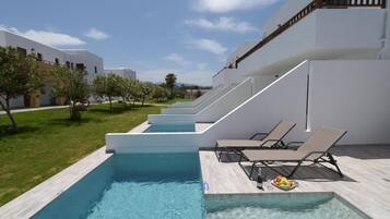 Departamento Deluxe, alberca privada, vista parcial al océano | Alberca | Alberca al aire libre por temporada y sombrillas en la alberca