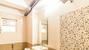 A bathroom with a toilet, sink, and shower. - Hotel Aura Residency (Bengaluru)