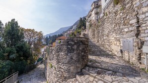 Eine steinerne Treppe führt einen Hügel hinauf, begleitet von Gebäuden an beiden Seiten.