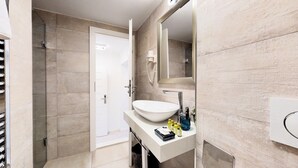 A modern bathroom with a large white sink, a mirror, and a shower area. - Apartment Nila by Litto (Split)