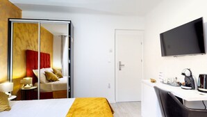 A hotel room with a bed, a desk with a coffee machine, a TV, and a wardrobe with a mirror. - Apartment Nila by Litto (Split)