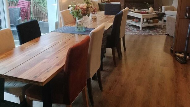 Ein modernes Wohnzimmer mit einem Holzesstisch, bequemen Sitzgelegenheiten und einem Kamin.