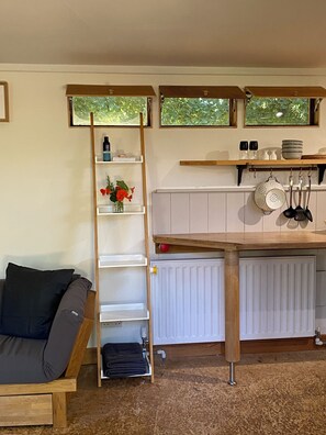 A cozy kitchen with a wooden table, a built-in shelf, and a radiator.