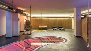 A spa area with a heated floor, a hanging chair, and two lounge chairs. - New modern apartments for active vacationers with wellness and pool. Dog friendly (Goldrain)