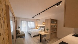 A modern bedroom with a bed, bedside table, and a desk with a chair. - New modern apartments for active vacationers with wellness and pool. Dog friendly (Goldrain)