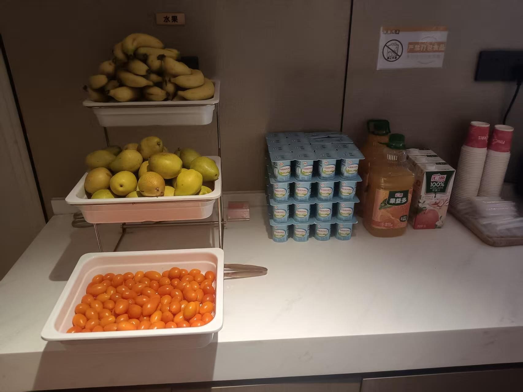 A buffet table with trays of fruits, dairy products, and condiments.