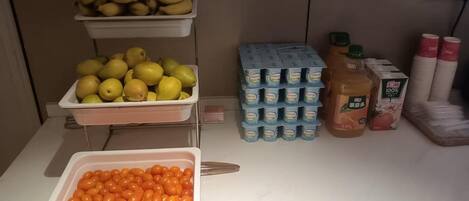 A buffet table with trays of fruits, dairy products, and condiments.