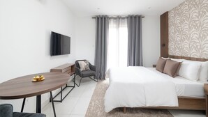 Une chambre d’hôtel moderne équipée d’un lit, d’un bureau et d’une télévision.