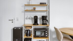 Eine Küchenzeile mit Kaffeemaschine, Toaster, Wasserkocher und einem Schild mit der Aufschrift ‚Kaffee‘ an der Wand.