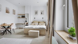 Ein modernes Schlafzimmer mit einem großen Bett, einem Schreibtisch und einer Essecke.