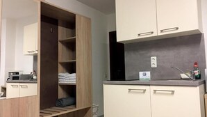 A modern bathroom with a wooden vanity, a mirror, a sink, and a towel rack. - Hana Aparthotel (Barsbuttel)