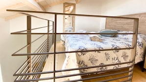 Une chambre avec un lit superposé, une lucarne et un plafond en bois.