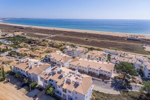 A coastal residential area with white buildings, a beach, and a clear sky. - Stunning beach house, panoramic views across Meia Praia bay (Lagos)