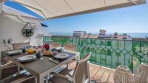 A balcony with a table set for breakfast, overlooking a coastal view. - Stunning beach house, panoramic views across Meia Praia bay (Lagos)